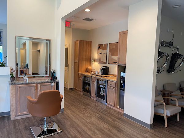 Inside Alora Salon & Wellness Spa in Robinson Township, with warm wood, plants and cream plaster
