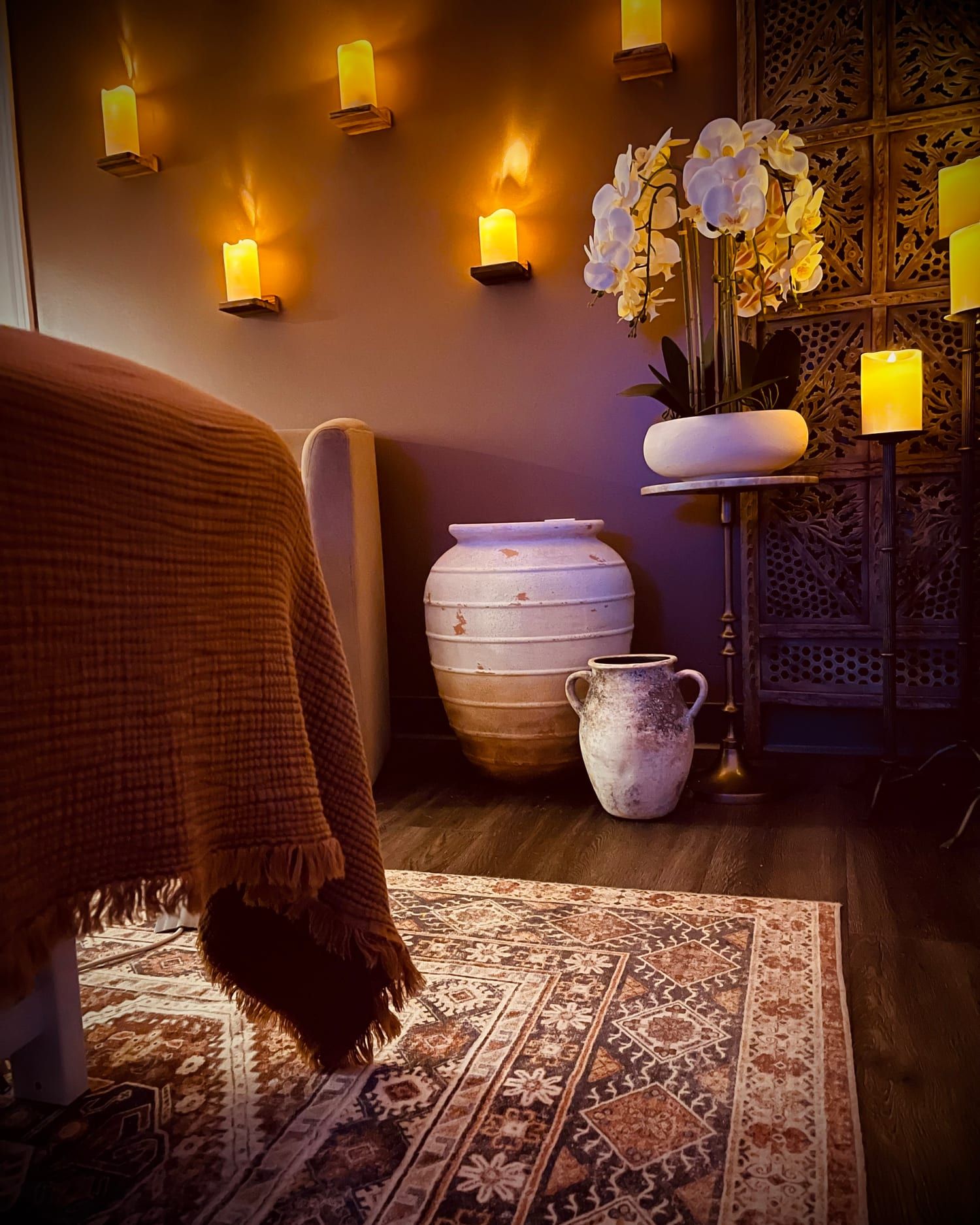 Candlelight, orchids, clay vessels and a terracotta throw in a treatment room at Alora Wellness Spa, Pittsburgh