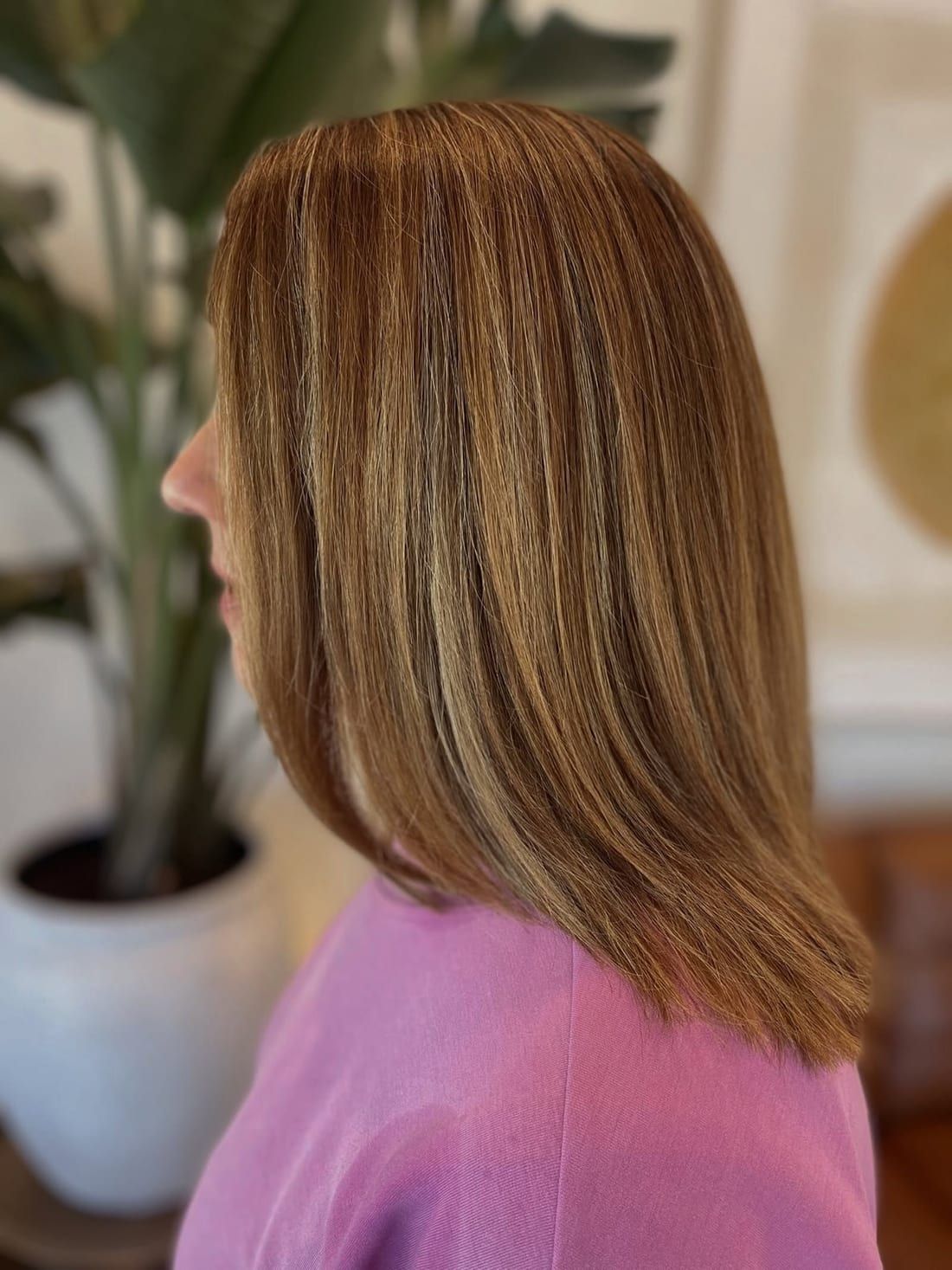 A caramel and copper lob with soft dimension through the mid-lengths, colored at Alora Salon in Robinson Township